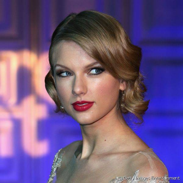 Em uma produ??o mais glamourosa, com fios em um falso chanel e com ondas largas, Taylor Swift compareceu ao baile de gala no Kensington Palace, em novembro de 2013, com esfumado dourado e marrom e boca em um vermelho rosado